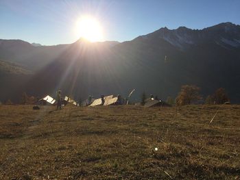 Scenic view of field against mountains at sunset