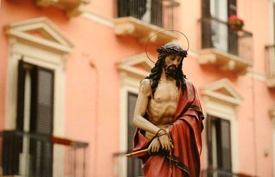 Low angle view of jesus christ statue against building