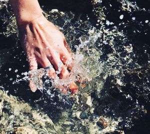 High angle view of person hand in water