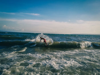 Man surfing in sea against sky