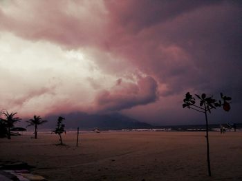 Scenic view of beach against cloudy sky