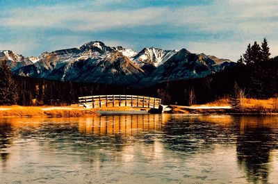 Scenic view of river by mountains against sky