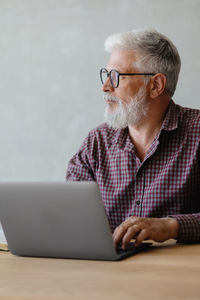 Senior man using laptop while sitting on table