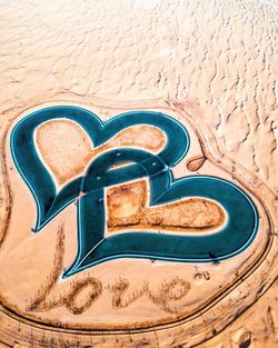 High angle view of heart shape on sand