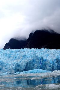 Glacier and lake against sky