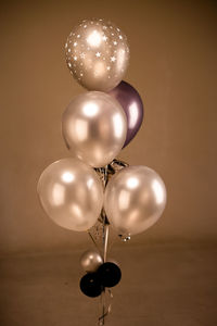 Low angle view of balloons hanging against wall