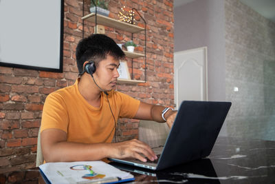 Young man using mobile phone while sitting in office