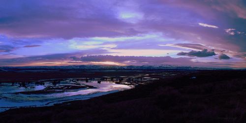 Scenic view of beach against dramatic sky