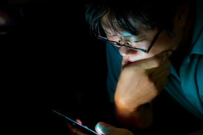 High angel view of man using phone in darkroom