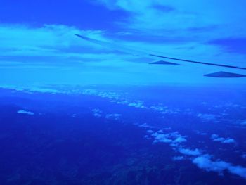 Airplane flying over sea against blue sky