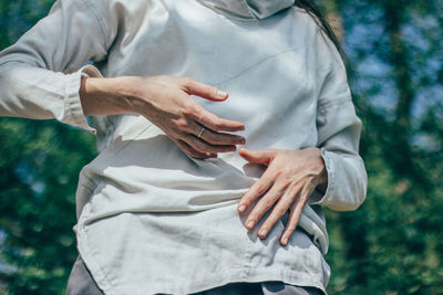 Midsection of woman with hands standing outdoors