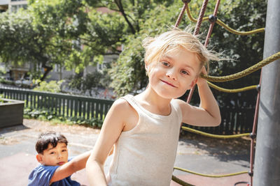 Child friends climbing net in park