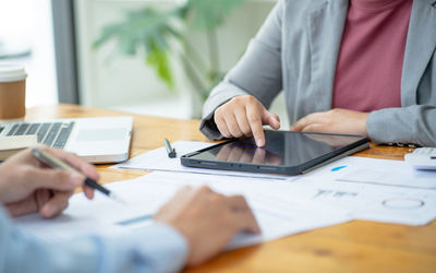 Midsection of business colleagues working on table