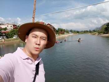 Portrait of man against lake in city