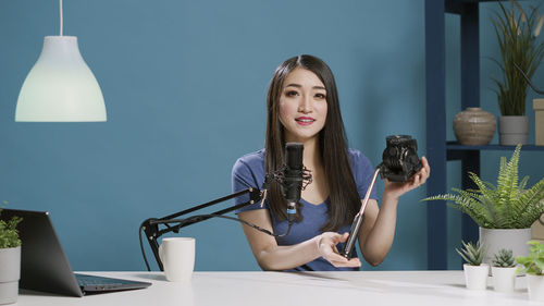 Portrait of young woman sitting on table