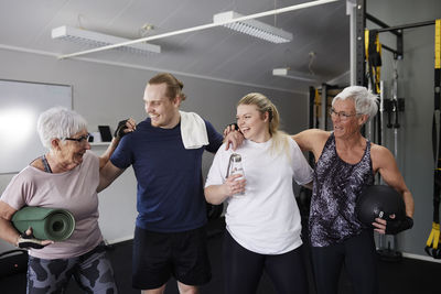 Happy people standing and talking in gym