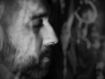 Young bearded man profile, eyes closed, thinking or dreaming, black and white, nose ring