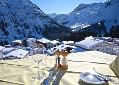 Wineglasses on table at restaurant against arlberg