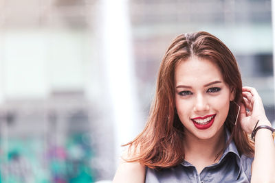 Close-up portrait of happy young woman in city