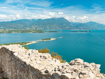 Lake garda and south alps peaks from the rocca di manerba ruins wall, manerba del garda, italy