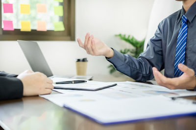 Midsection of business colleagues working on table