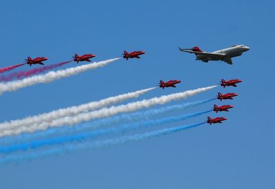 Low angle view of airshow against sky