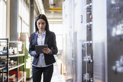 Businesswoman using tablet in a modern factory