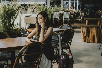 Portrait of woman sitting on chair at table