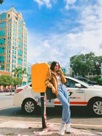 Full length of woman standing on road in city