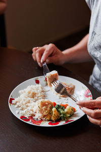 Midsection of woman holding food in plate