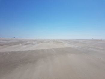 Scenic view of desert against clear blue sky