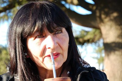 Thoughtful woman having drink outdoors