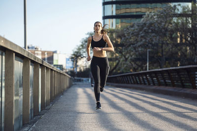 Woman running on footbridge