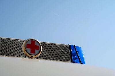 Low angle view of road sign against blue sky