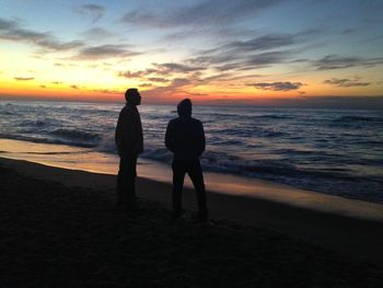 Silhouette of people standing on beach