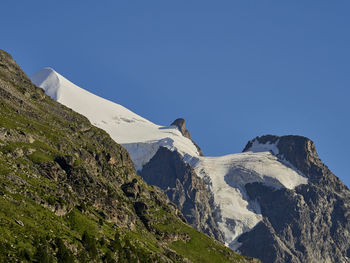 Scenic view of snowcapped mountains against clear blue sky