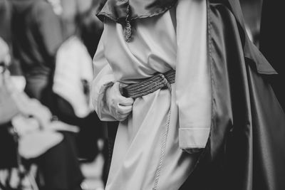 Midsection of man holding woman standing against blurred background