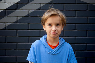 Portrait of boy against wall outdoors