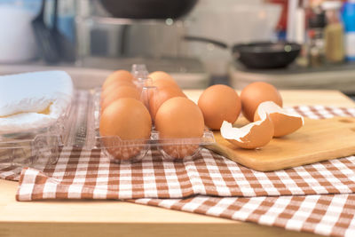 Close-up of egg carton with fabric on table