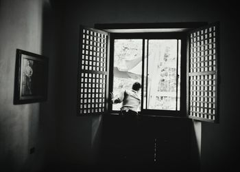 Man standing by window at home