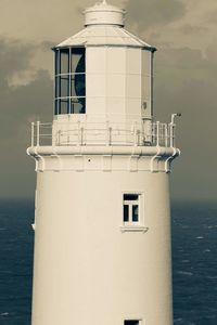 Lighthouse by sea against sky