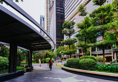 People walking on footpath amidst buildings in city