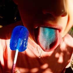 Close-up of boy sticking out tongue while holding flavored ice