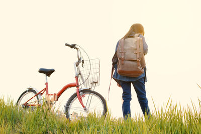 Woman with bicycle on field