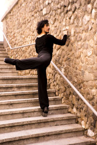 Man dancing on steps against wall