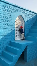 Kid standing on staircase against wall