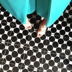 Low section of woman standing on patterned floor