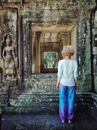 Rear view of woman standing against building