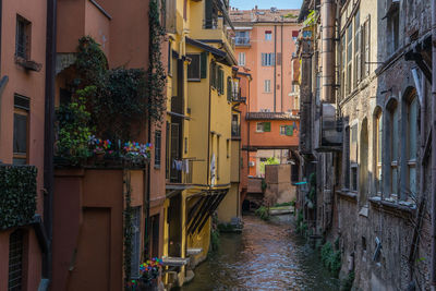 Canal amidst buildings in city during rainy season