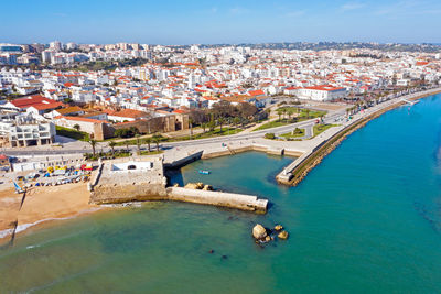 High angle view of townscape by sea against sky